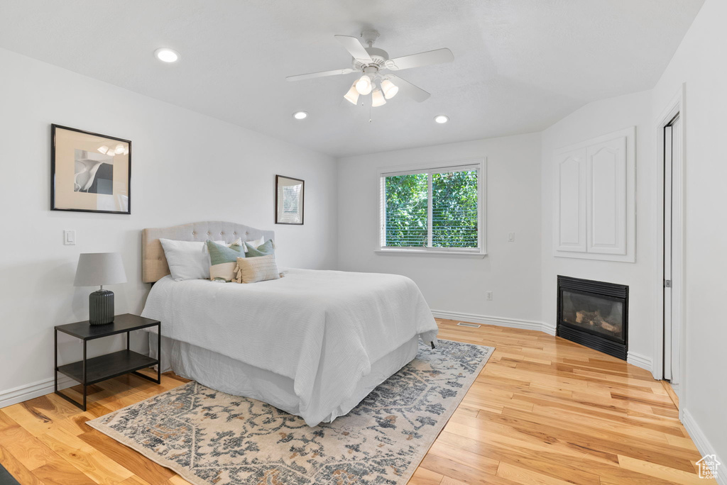 Bedroom with lofted ceiling, light wood-type flooring, and ceiling fan