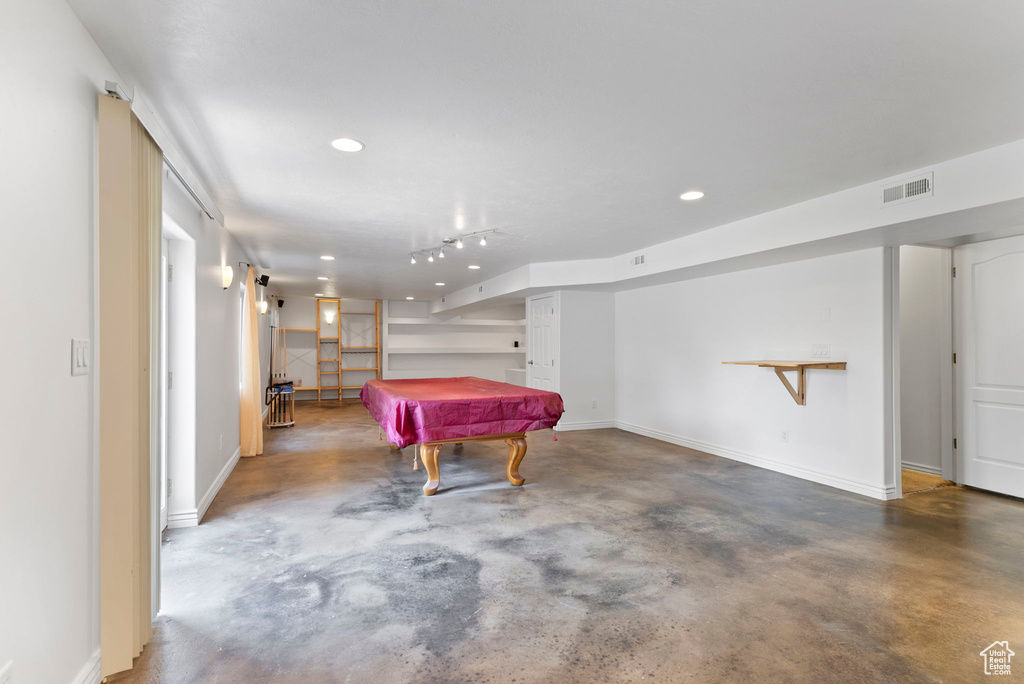 Interior space featuring rail lighting, concrete flooring, and billiards