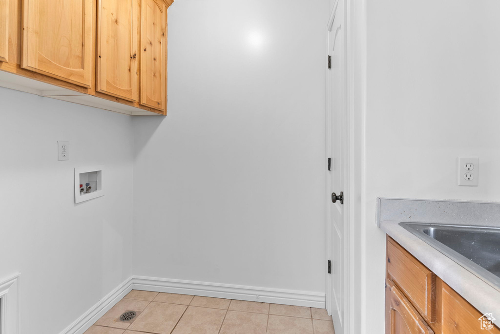 Laundry room featuring cabinets, hookup for a washing machine, and light tile patterned floors