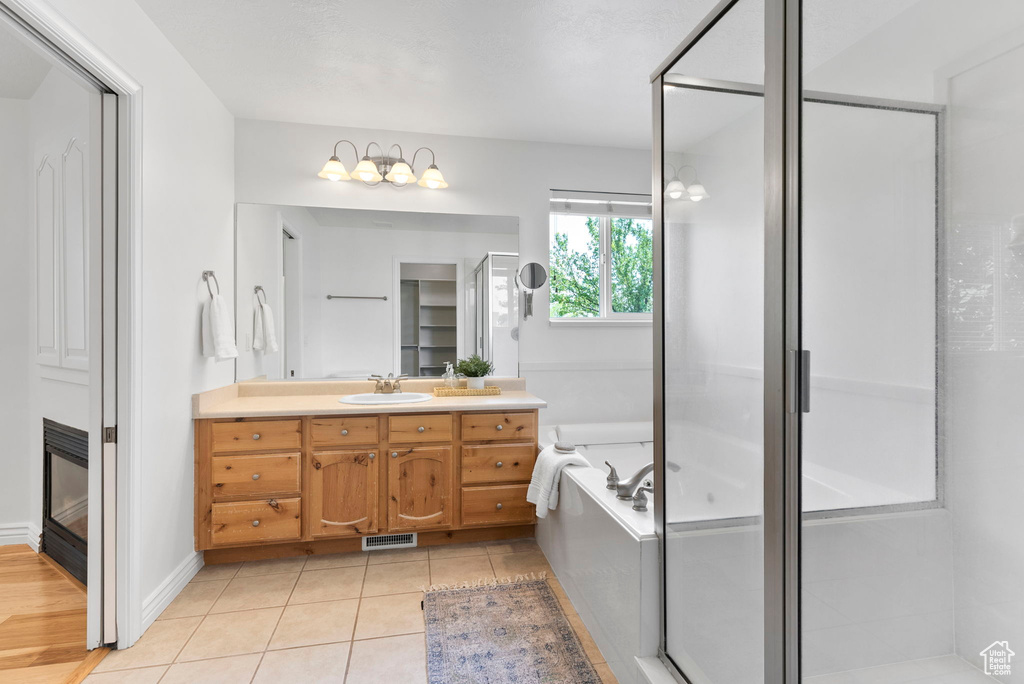 Bathroom with shower with separate bathtub, wood-type flooring, and vanity