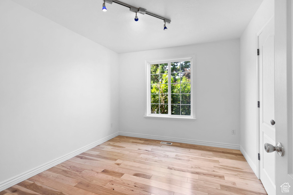 Unfurnished room featuring light wood-type flooring and track lighting