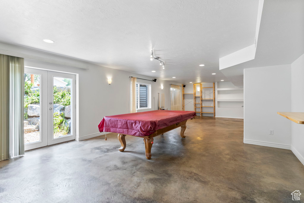 Recreation room featuring track lighting, pool table, french doors, and concrete flooring