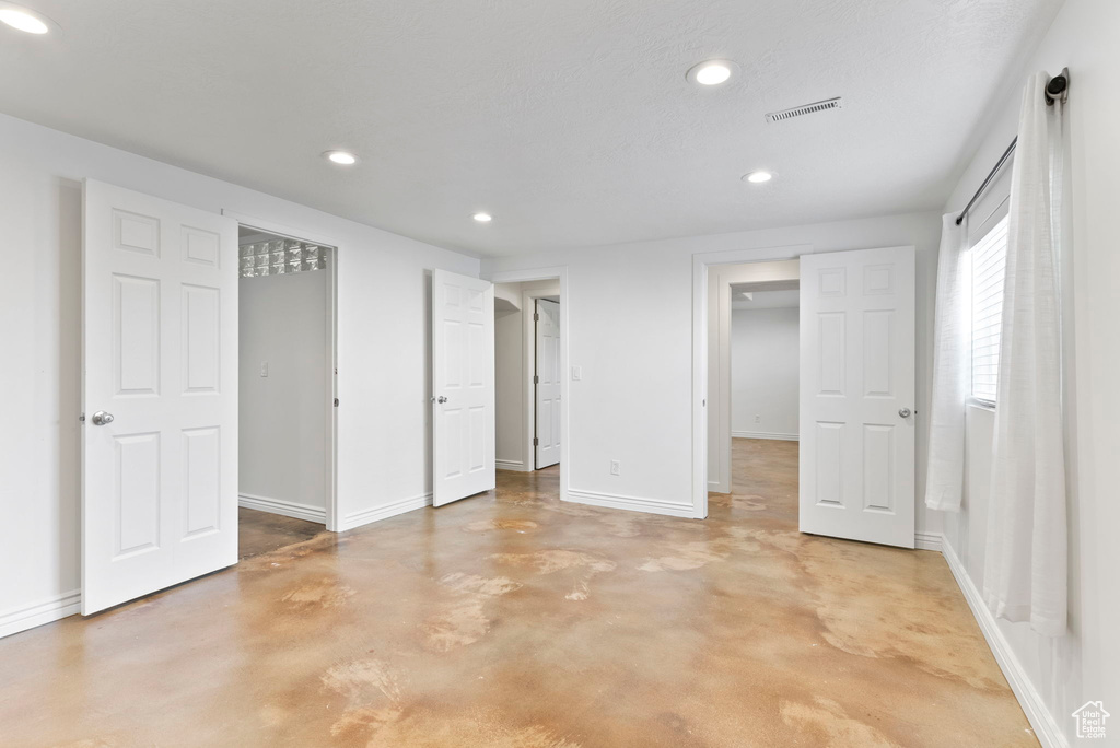 Unfurnished bedroom featuring concrete flooring