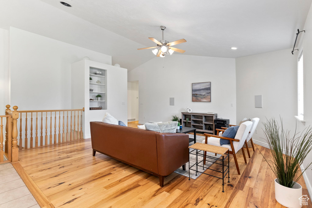 Living room with vaulted ceiling, light hardwood / wood-style flooring, and ceiling fan