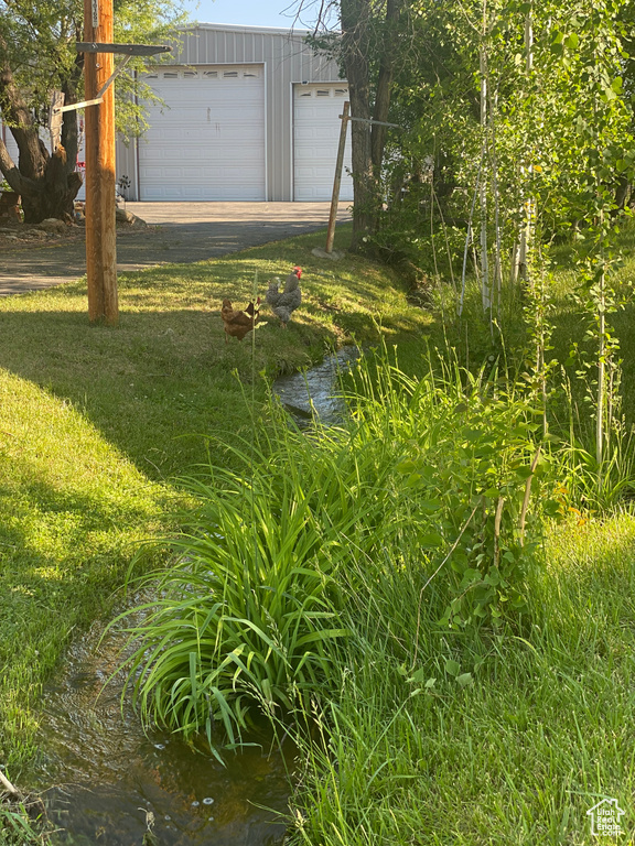 View of yard with a garage and a water view