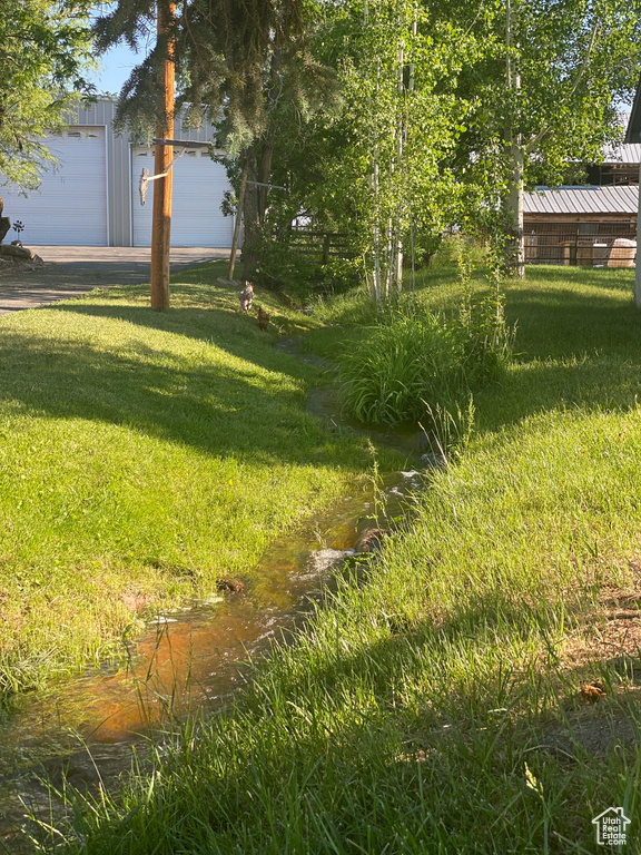 View of yard with a garage and a water view