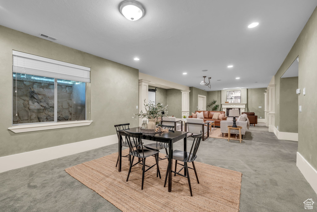 Carpeted dining space with ornate columns