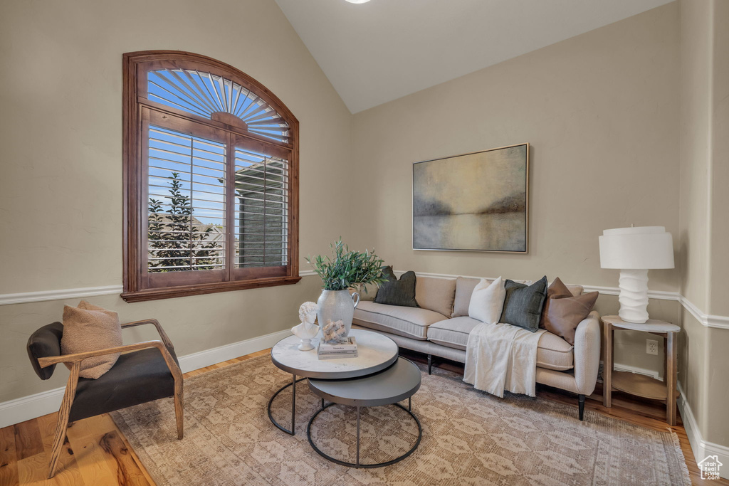 Living room with hardwood / wood-style floors and vaulted ceiling