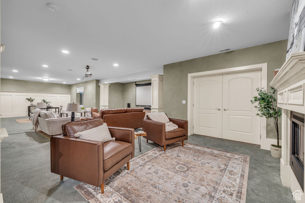 Carpeted living room with decorative columns