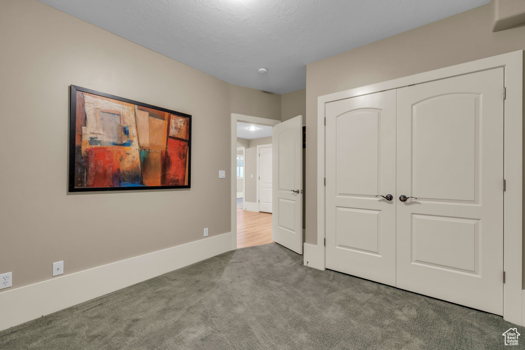 Unfurnished bedroom featuring a closet and carpet floors