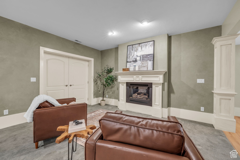 Living room with decorative columns and light hardwood / wood-style flooring