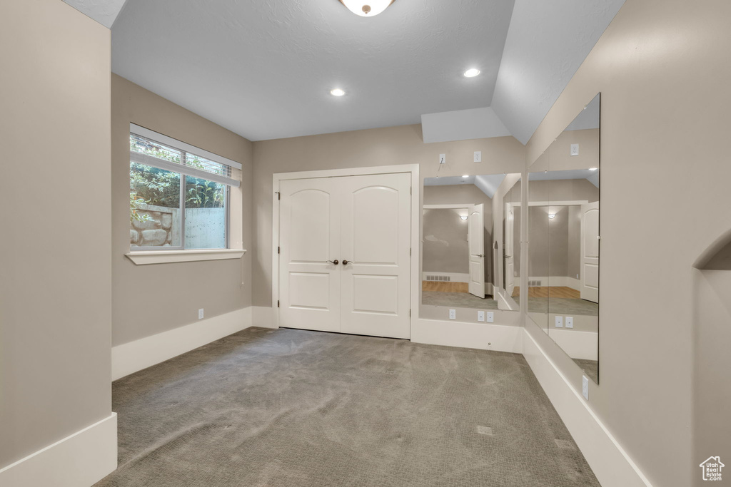 Interior space featuring carpet floors and lofted ceiling