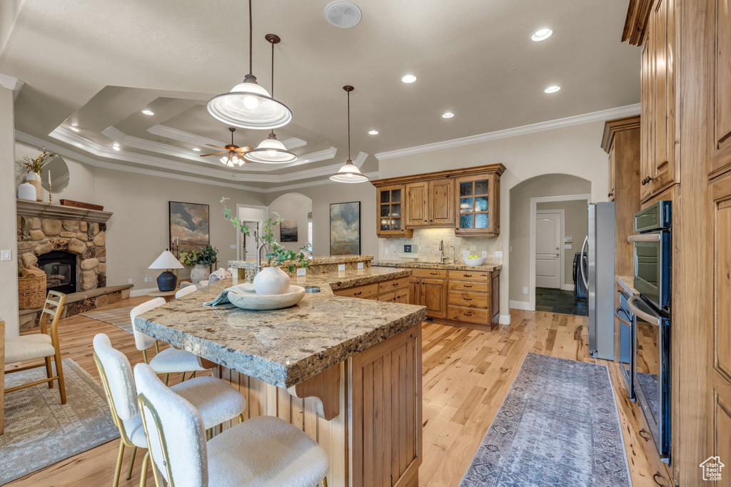 Kitchen featuring crown molding, a fireplace, and ceiling fan