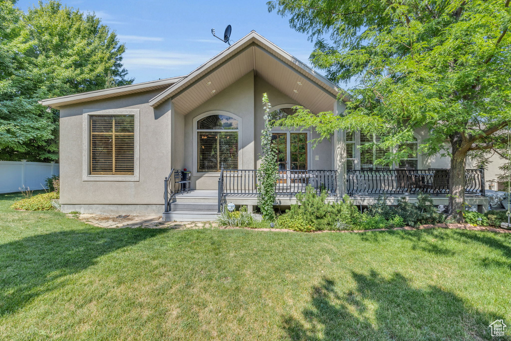 View of front facade with a deck and a front lawn