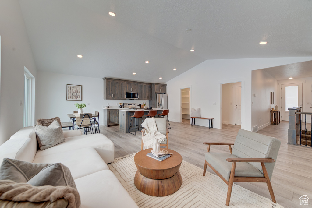 Living room featuring lofted ceiling and light wood-type flooring