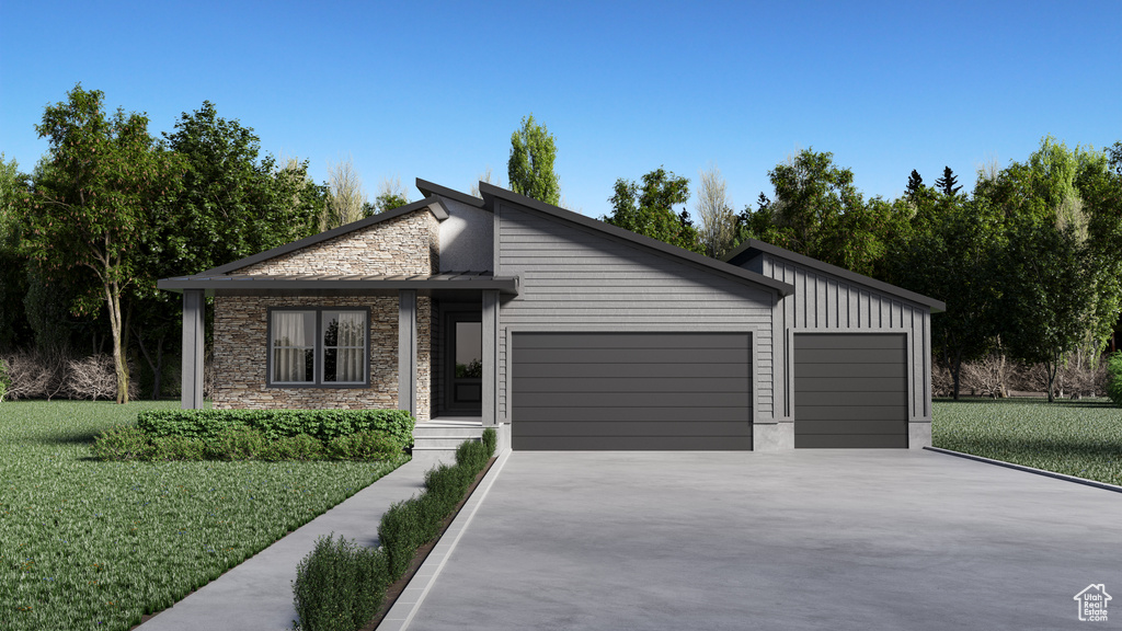 View of front of property featuring a garage and a front yard