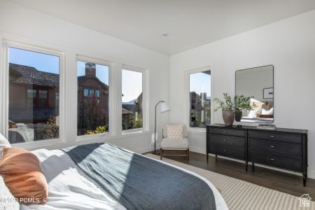 Bedroom with dark hardwood / wood-style flooring and multiple windows