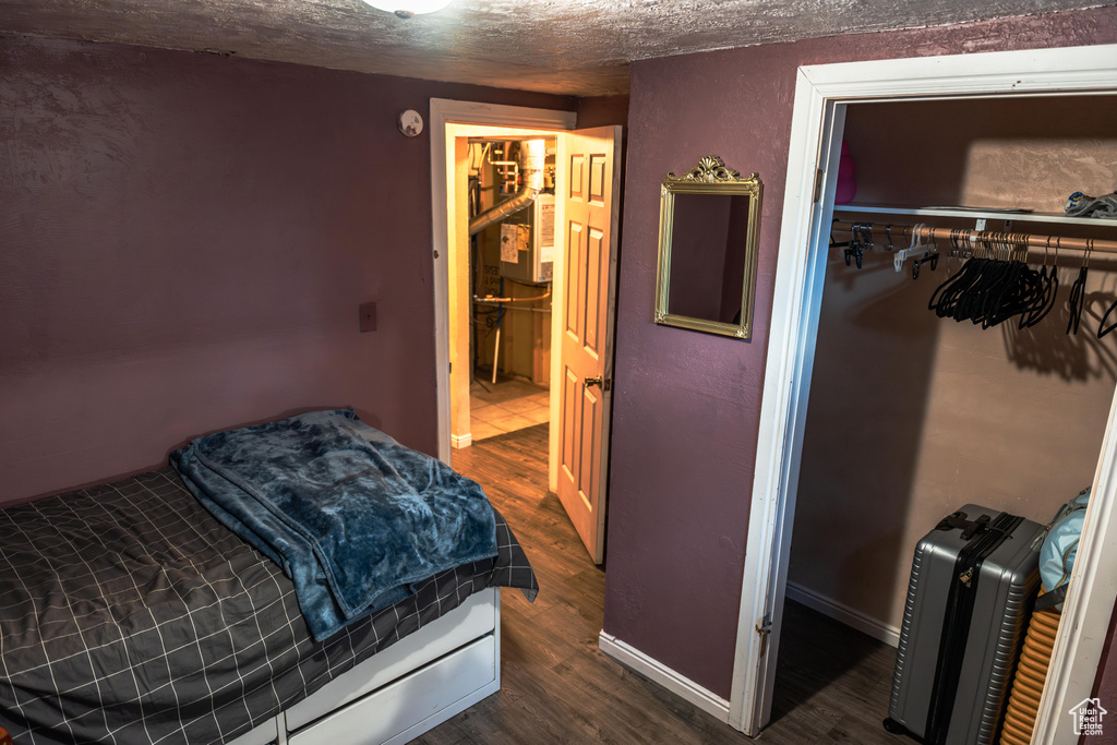 Bedroom featuring a textured ceiling and dark hardwood / wood-style flooring