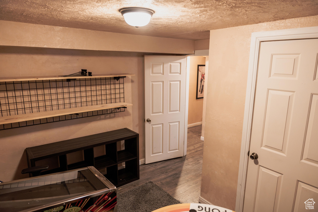 Bedroom with a textured ceiling and dark wood-type flooring