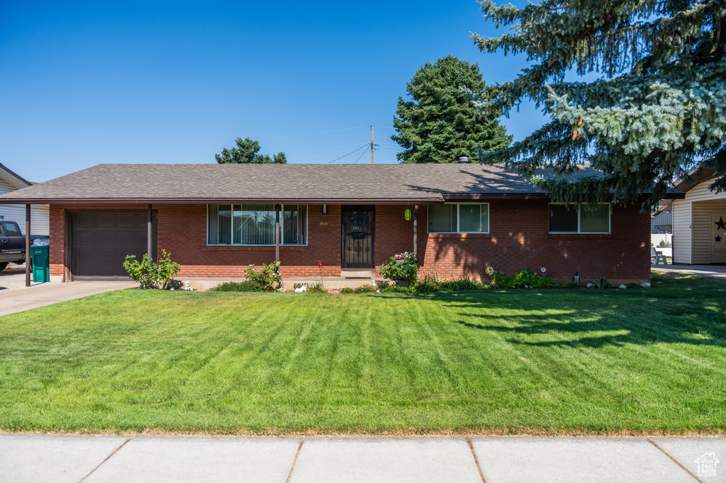 Ranch-style home with a garage and a front yard