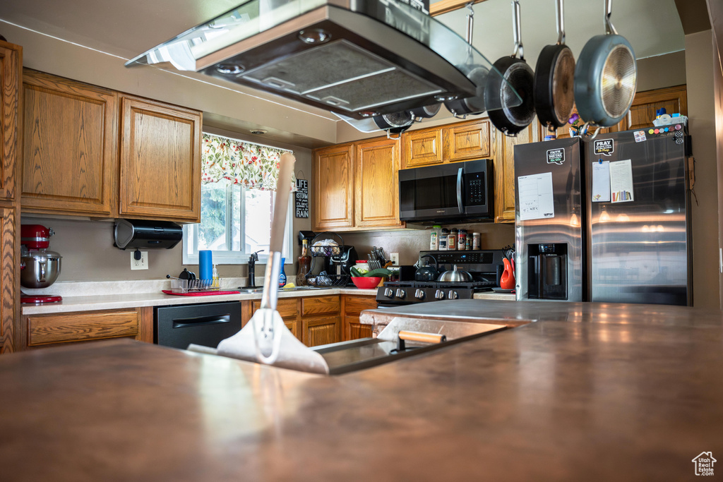 Kitchen with black appliances, custom exhaust hood, and sink