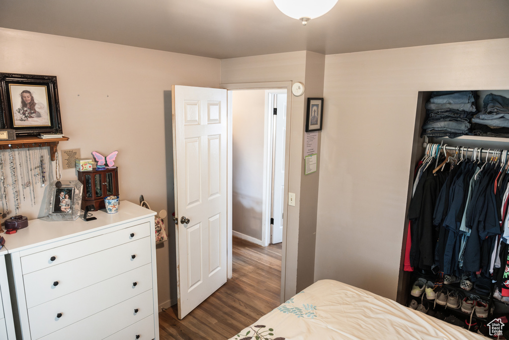 Bedroom with a closet and dark hardwood / wood-style floors