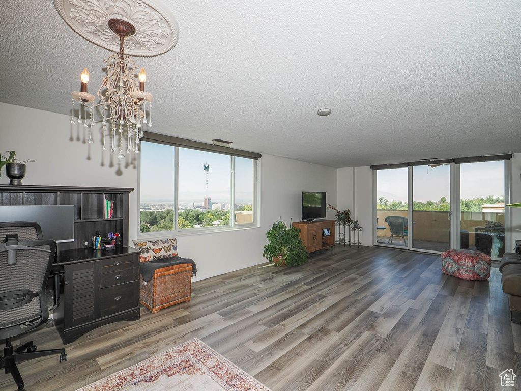 Office space with an inviting chandelier, hardwood / wood-style flooring, and a textured ceiling