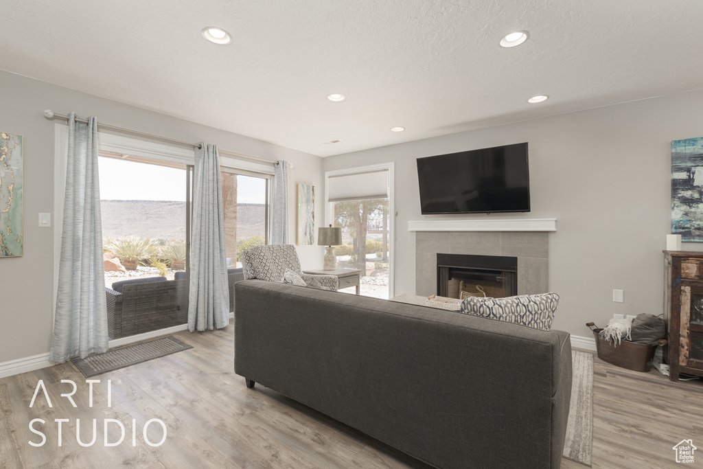 Living room featuring light hardwood / wood-style floors and a tiled fireplace