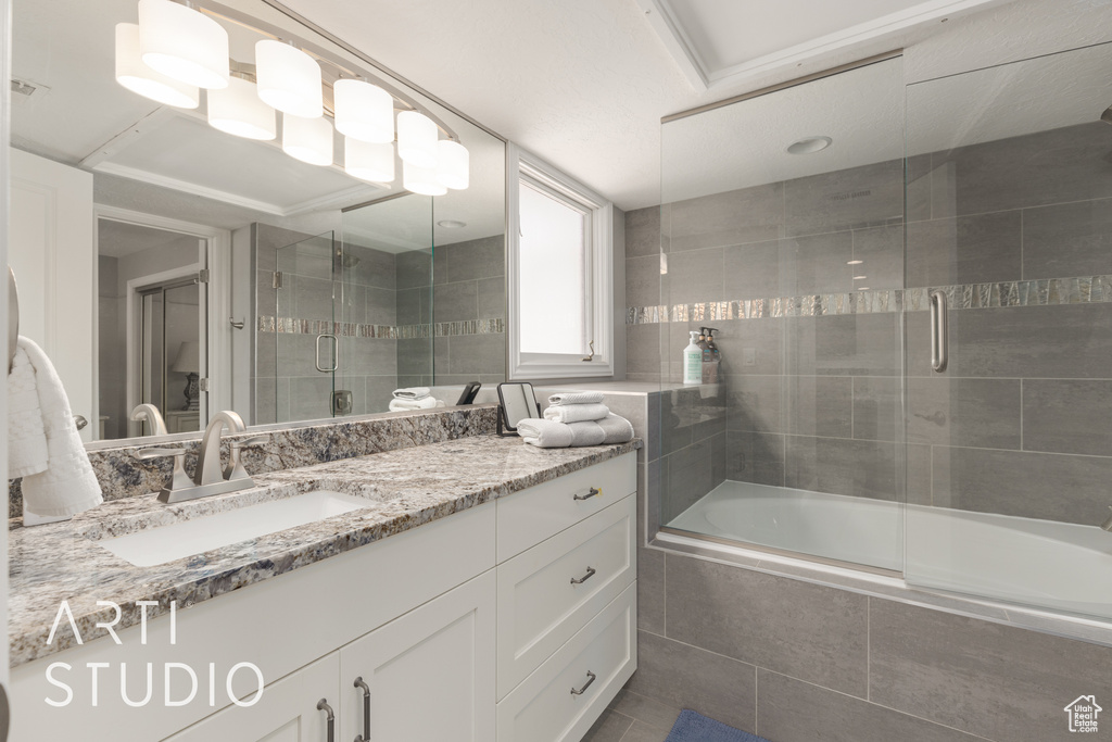 Bathroom with vanity, bath / shower combo with glass door, and tile patterned floors