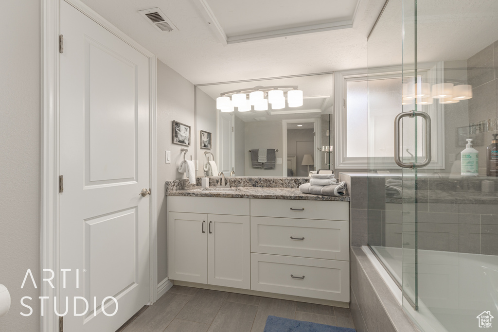 Bathroom featuring vanity, wood-type flooring, and enclosed tub / shower combo