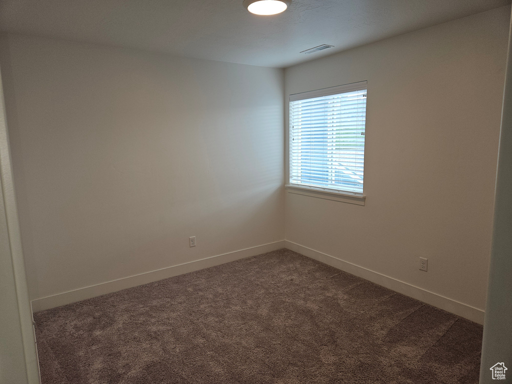 Unfurnished room with dark colored carpet