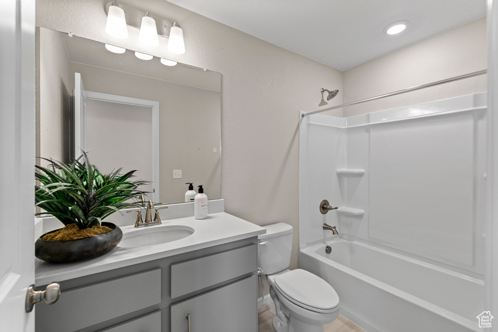 Full bathroom with vanity, bathtub / shower combination, and toilet