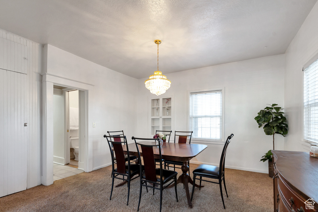 Carpeted dining area with a chandelier