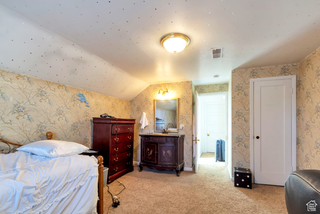 Bedroom featuring lofted ceiling and light carpet