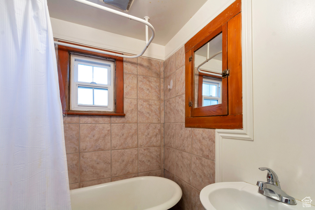 Bathroom with shower / bath combo with shower curtain and sink