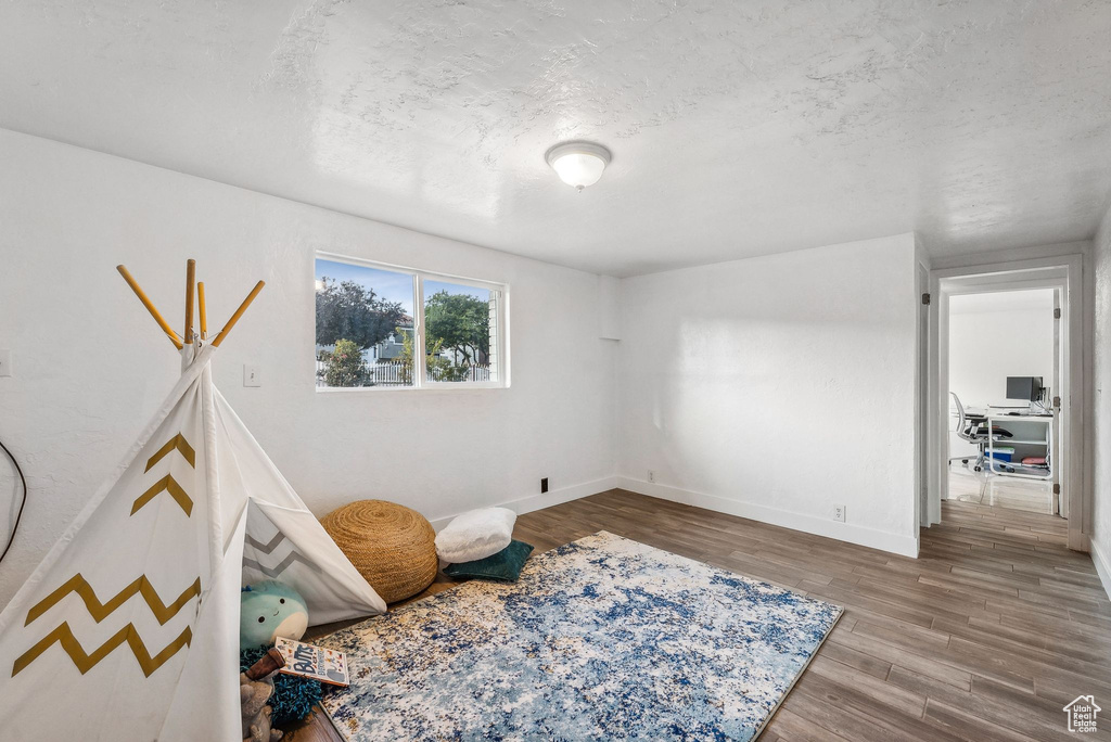 Interior space featuring a textured ceiling and wood-type flooring