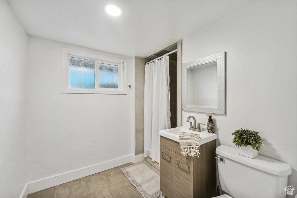 Bathroom with tile patterned flooring, toilet, and vanity