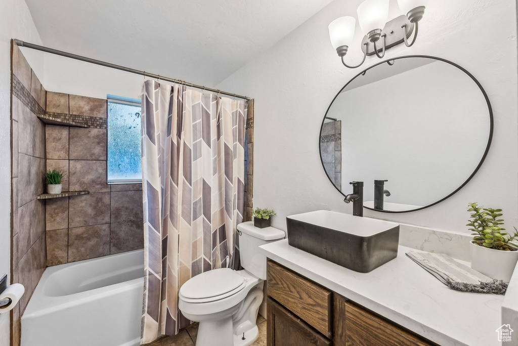 Full bathroom featuring tile patterned floors, toilet, vanity, and shower / tub combo with curtain