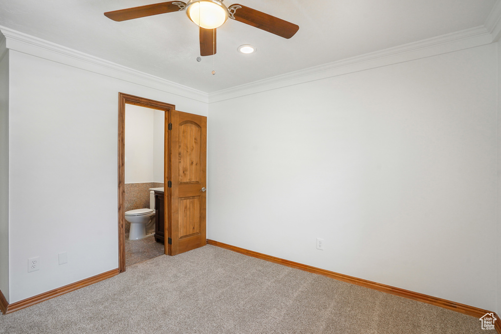 Unfurnished bedroom featuring ornamental molding, carpet, connected bathroom, and ceiling fan