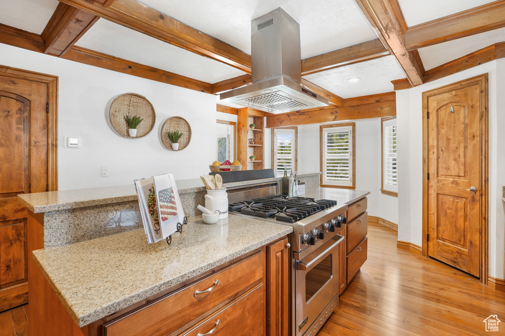 Kitchen featuring premium range, a center island, beamed ceiling, light hardwood / wood-style floors, and island range hood