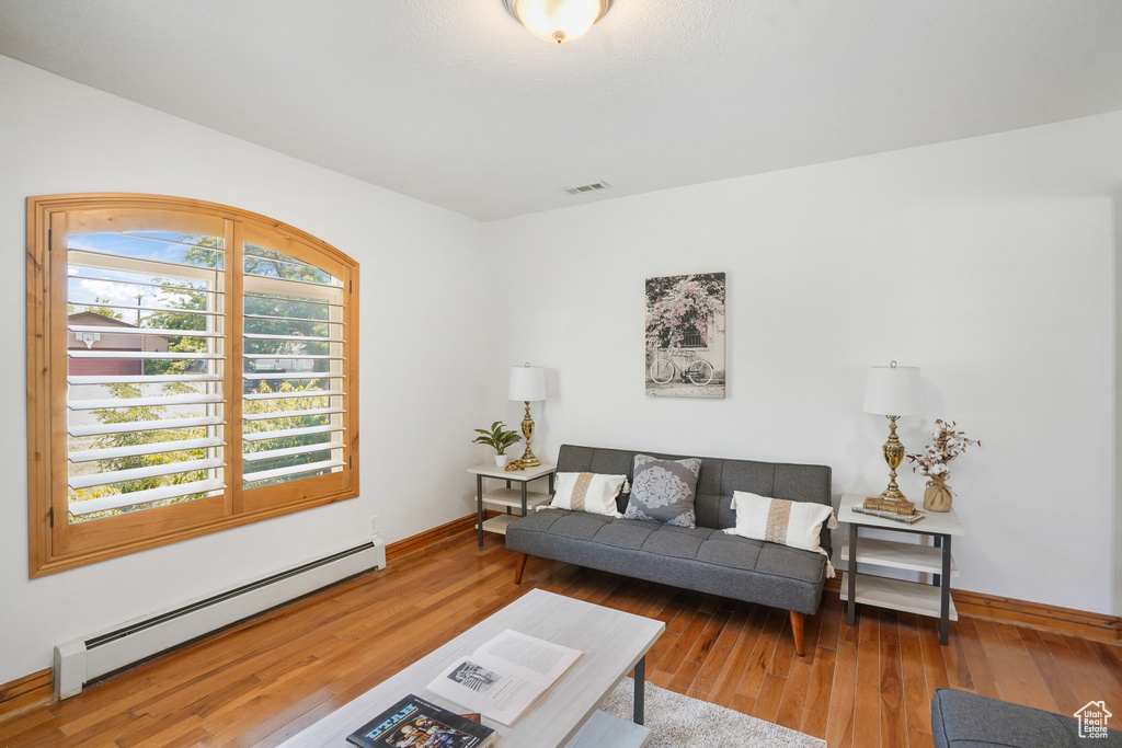 Living room featuring wood-type flooring and a baseboard radiator