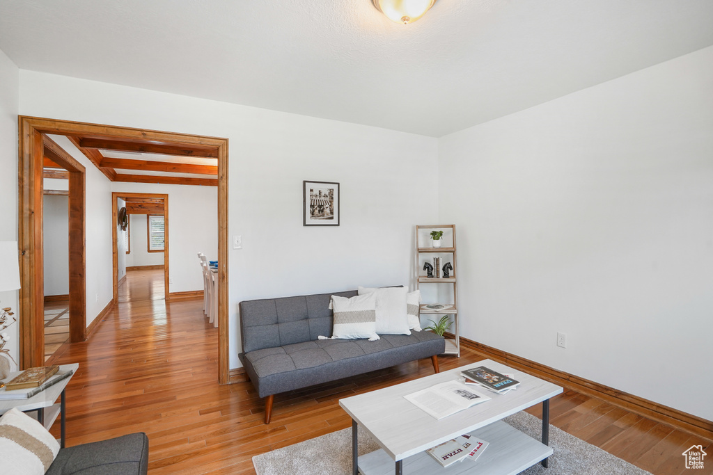 Living room with beam ceiling and hardwood / wood-style flooring