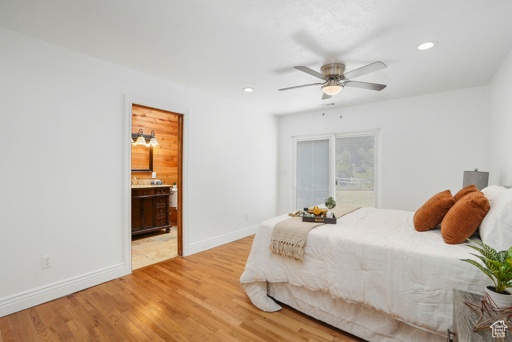 Bedroom featuring ensuite bathroom, ceiling fan, and light tile patterned floors