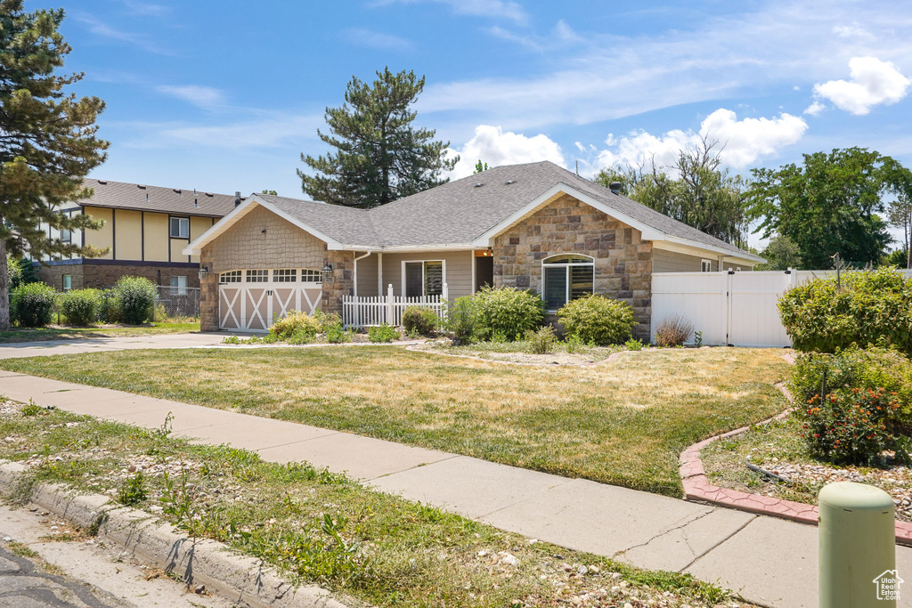 Ranch-style home featuring a garage and a front lawn