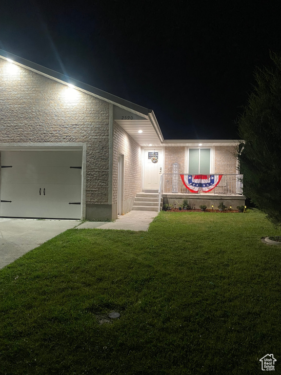 View of front facade with a garage and a yard