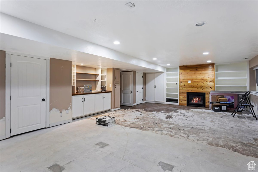 Unfurnished living room featuring wood walls and a large fireplace