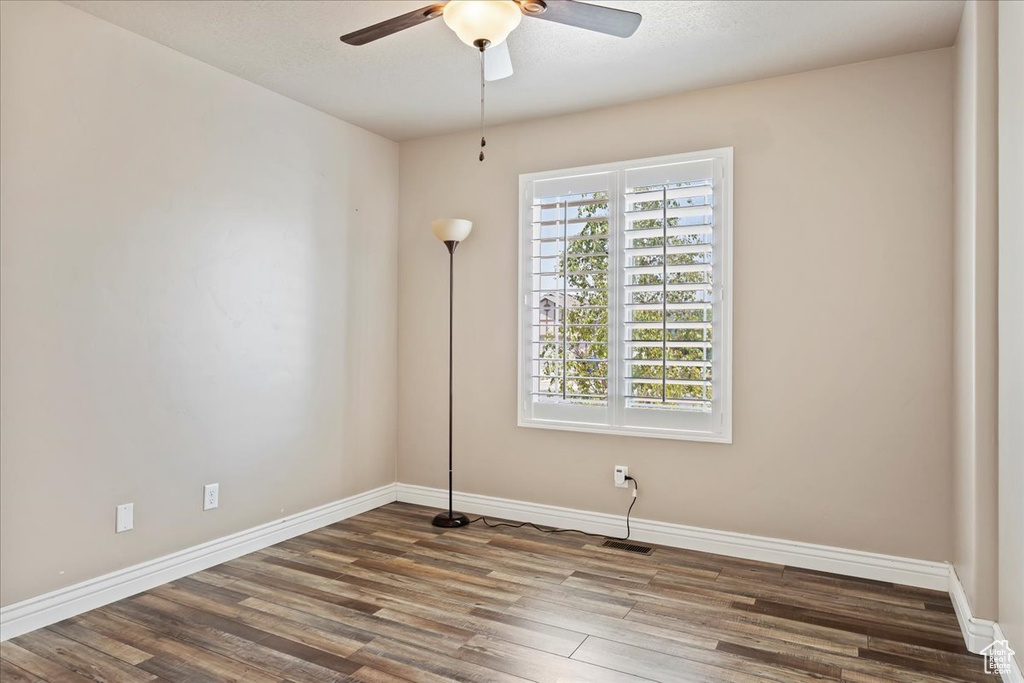 Spare room featuring hardwood / wood-style floors, a wealth of natural light, and ceiling fan