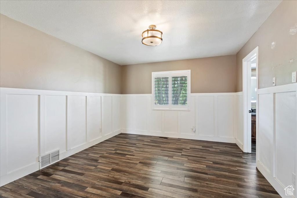 Spare room featuring dark wood-type flooring