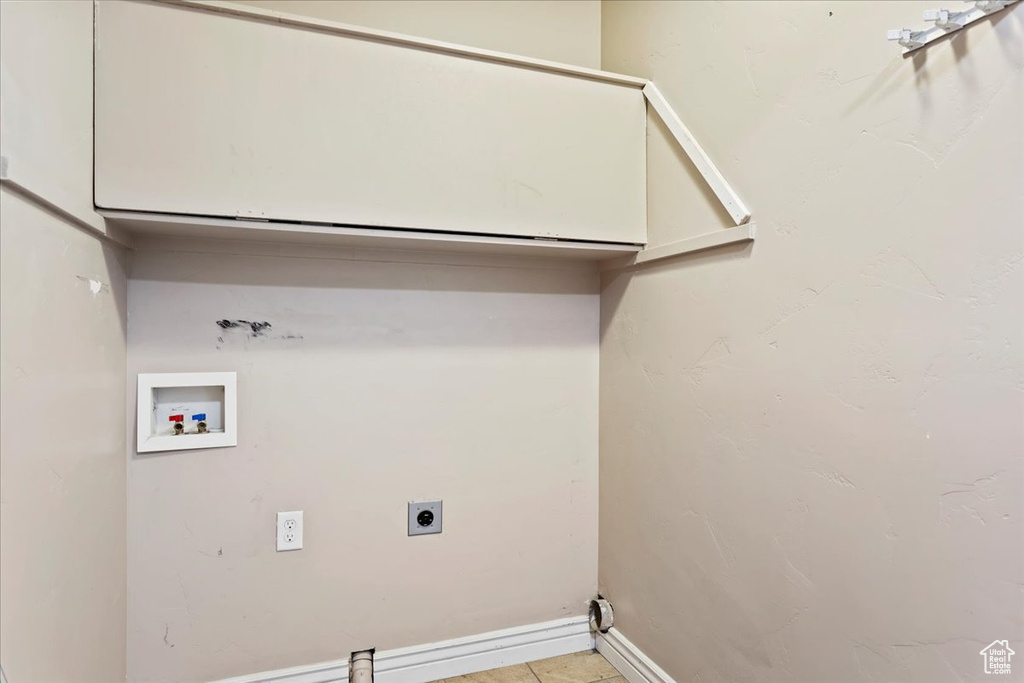 Clothes washing area with electric dryer hookup, washer hookup, and light tile patterned floors