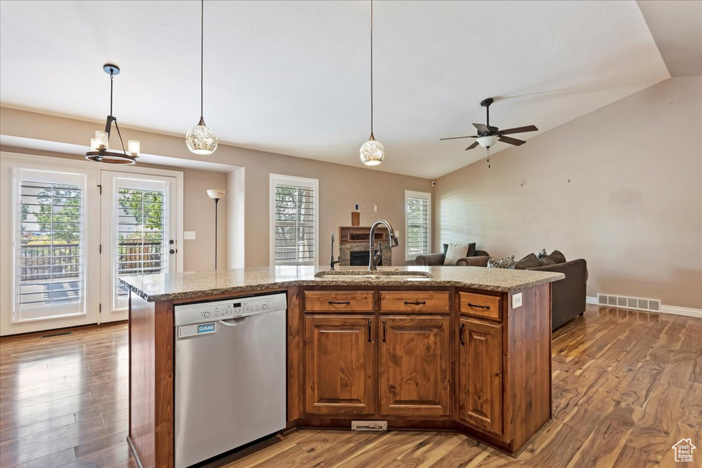 Kitchen with dishwasher, a kitchen island with sink, and vaulted ceiling